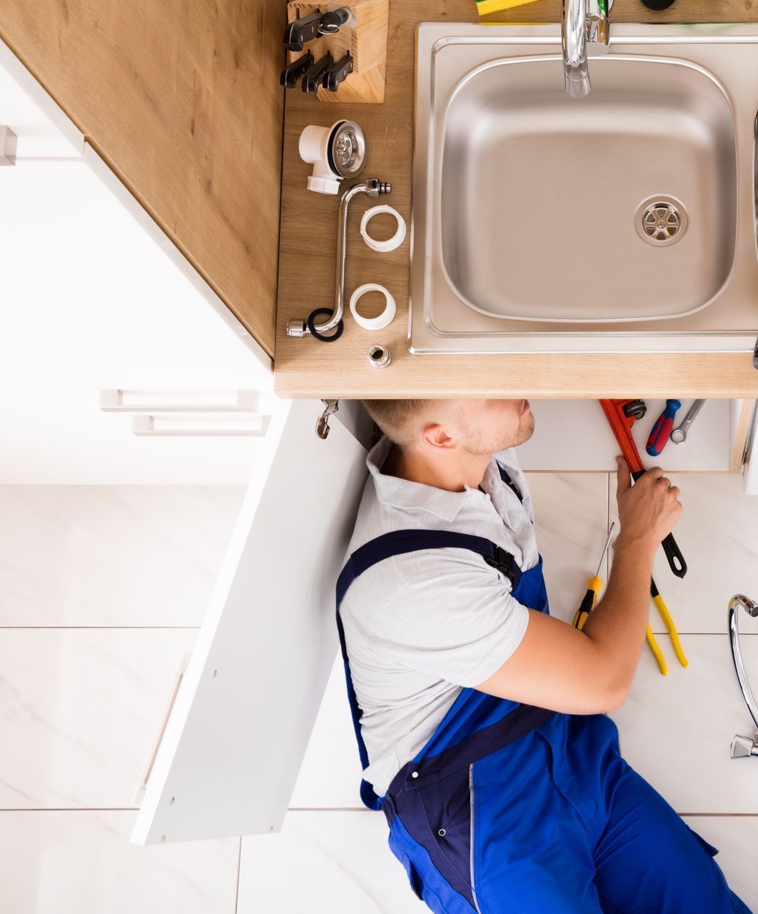 Male plumber fixing sink pipe